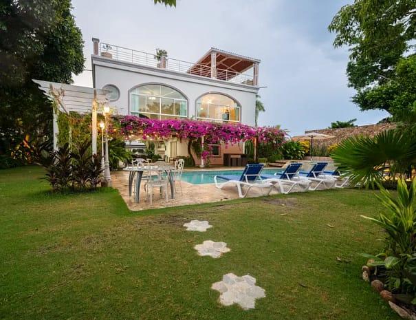 Exterior of a beachfront villa in Punta Chame showing a private pool, jacuzzi, tropical gardens, and illuminated facade at dusk by Bannaba Stays in Panama